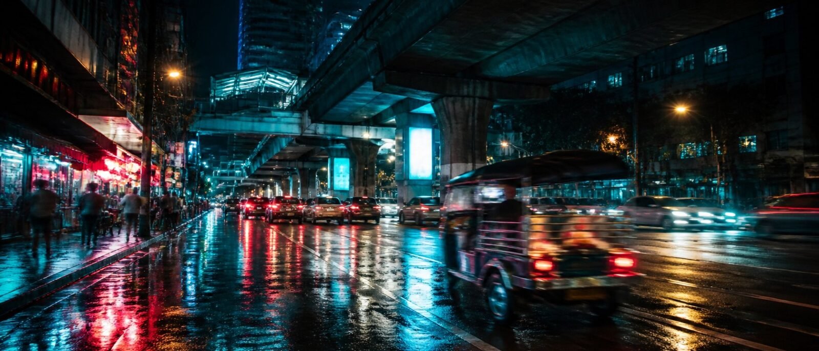 Bangkok street at night with neon reflections and a tuk-tuk